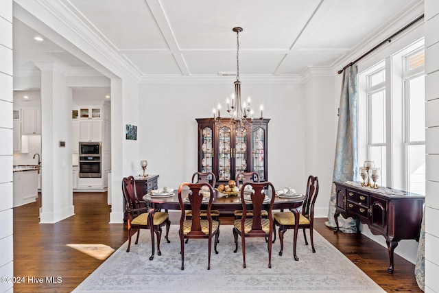 dining area featuring dark wood-type flooring, a notable chandelier, and ornamental molding