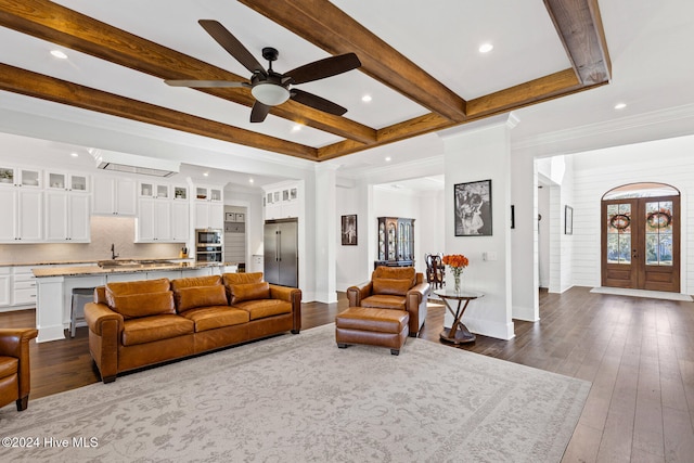 living room with dark wood-type flooring, french doors, crown molding, ceiling fan, and beamed ceiling