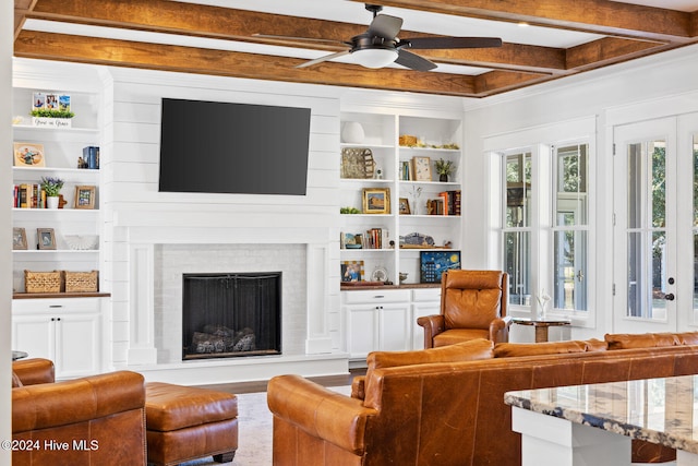 living room with beamed ceiling, ceiling fan, and built in shelves