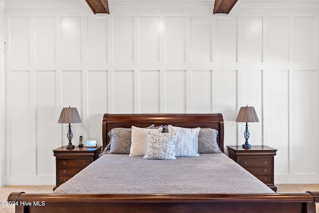 carpeted bedroom featuring beamed ceiling and ceiling fan