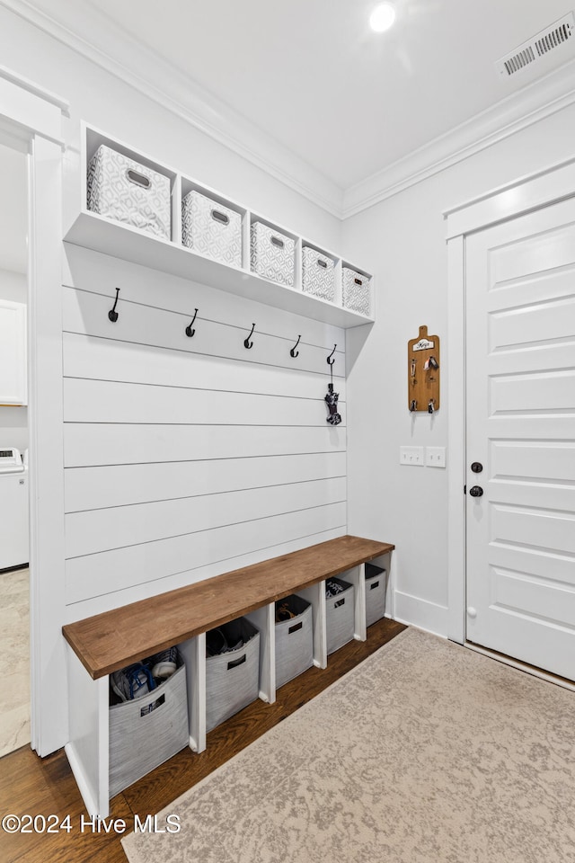 mudroom featuring ornamental molding, dark wood-type flooring, and washer / clothes dryer