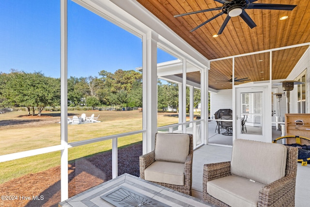 sunroom featuring ceiling fan and wood ceiling