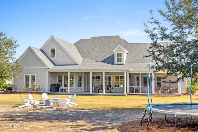 back of property with a trampoline and a patio