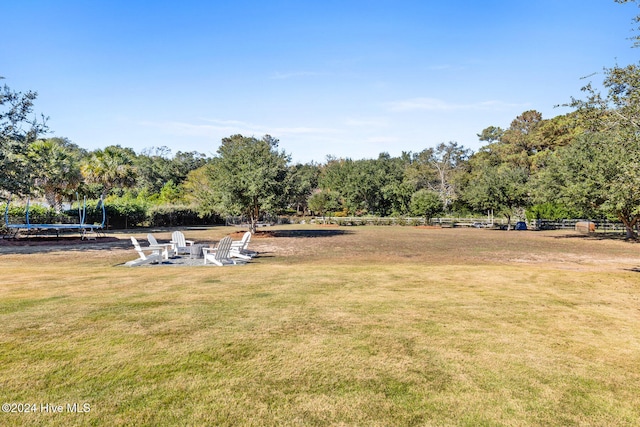 view of yard featuring an outdoor fire pit and a trampoline