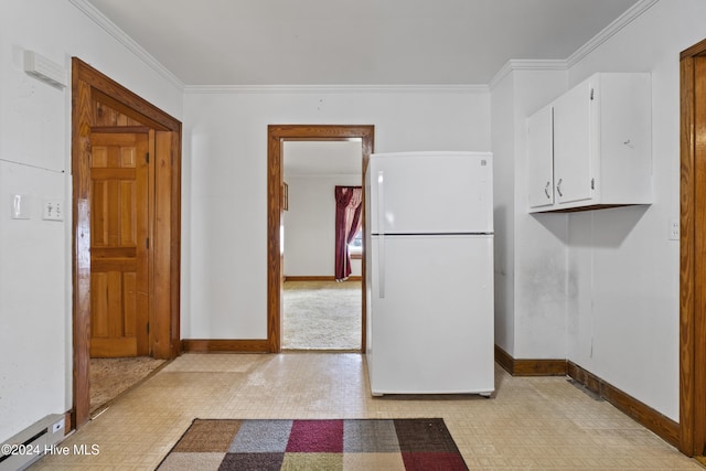 kitchen featuring white cabinets, white fridge, and ornamental molding