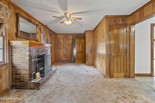 unfurnished living room with a baseboard heating unit, ceiling fan, a textured ceiling, and a brick fireplace