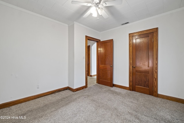 unfurnished bedroom featuring ceiling fan, crown molding, and light carpet