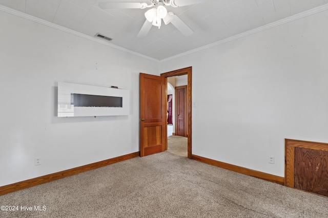 unfurnished room with carpet floors, ceiling fan, and crown molding