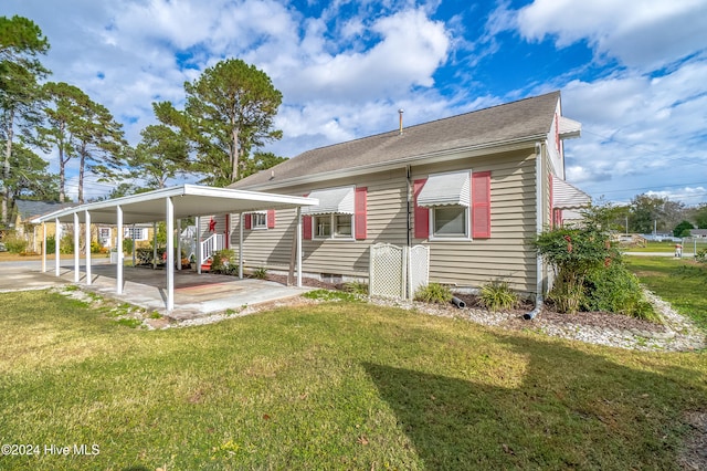 back of house with a lawn and a carport