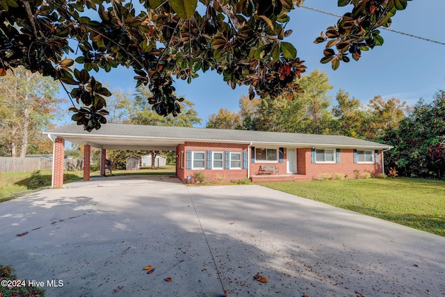 ranch-style house featuring a front lawn and a carport