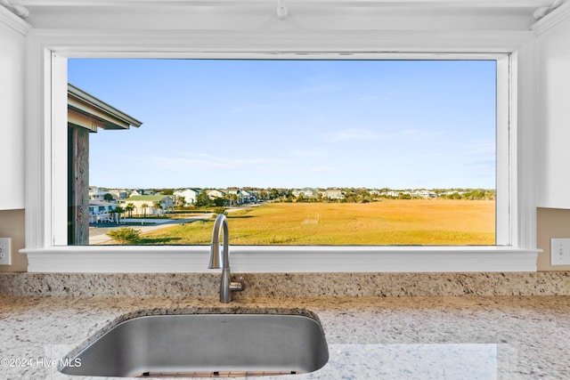 interior details with light stone counters and a sink