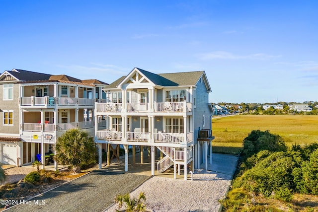 coastal home featuring a carport, a residential view, driveway, and a balcony