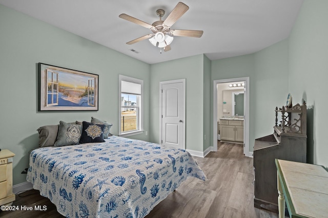 bedroom with ceiling fan, ensuite bathroom, and light wood-type flooring