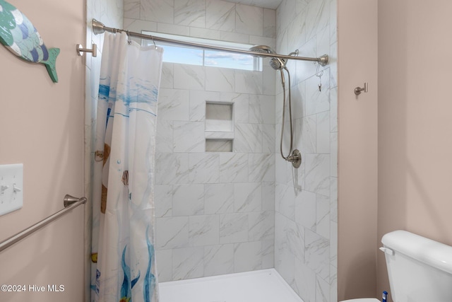 bathroom featuring curtained shower and toilet