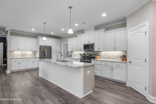 kitchen featuring stainless steel appliances, a kitchen island with sink, sink, pendant lighting, and white cabinetry