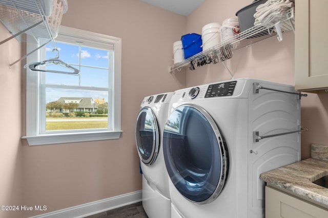 clothes washing area with washing machine and dryer, plenty of natural light, and dark wood-type flooring