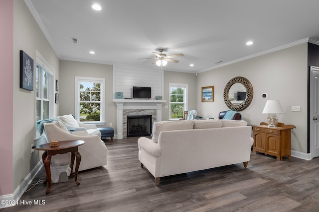 living room with dark hardwood / wood-style floors, ceiling fan, crown molding, and a high end fireplace