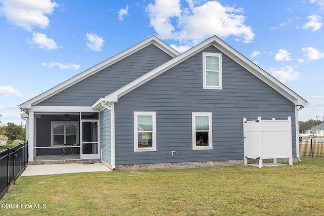 rear view of property featuring a sunroom and a yard