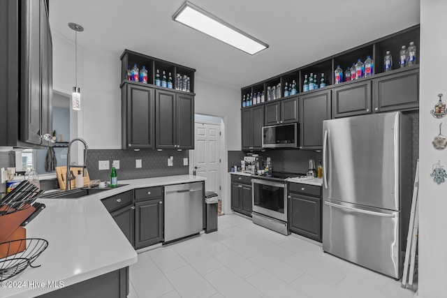 kitchen with backsplash, sink, pendant lighting, and appliances with stainless steel finishes