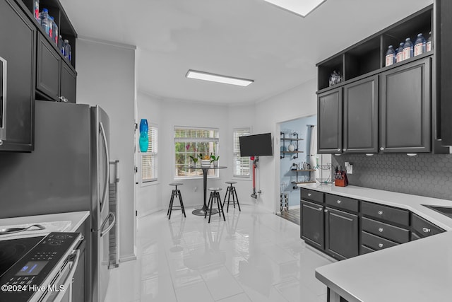 kitchen with decorative backsplash, appliances with stainless steel finishes, and light tile patterned floors