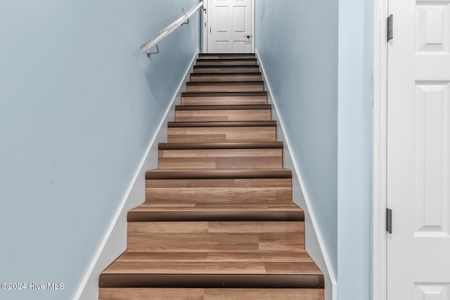 staircase with hardwood / wood-style flooring