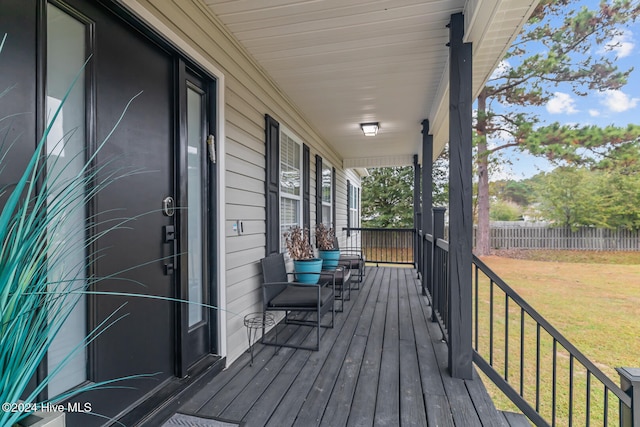 wooden deck with covered porch and a yard