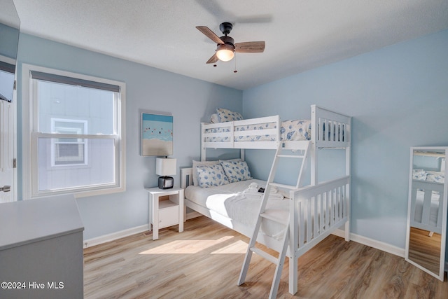 bedroom with ceiling fan, a textured ceiling, and light wood-type flooring