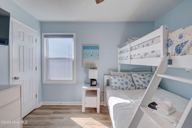 bedroom featuring light hardwood / wood-style floors and a textured ceiling