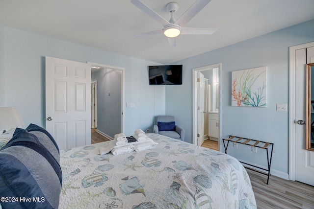 bedroom with light hardwood / wood-style floors, ensuite bath, and ceiling fan