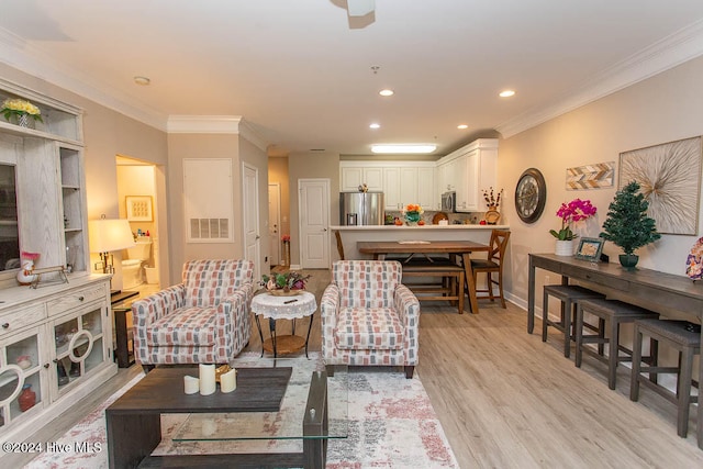 living room with ornamental molding and light hardwood / wood-style flooring