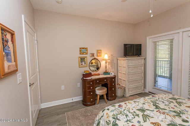 bedroom with access to exterior, dark wood-type flooring, and ceiling fan