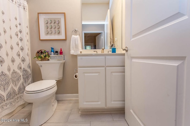 bathroom with toilet, vanity, and tile patterned floors