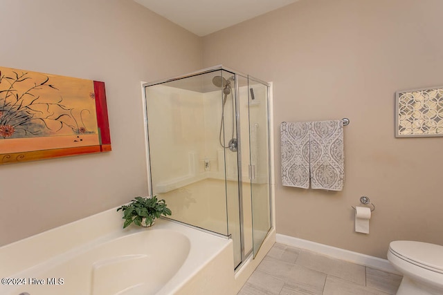 bathroom featuring tile patterned flooring, toilet, and separate shower and tub