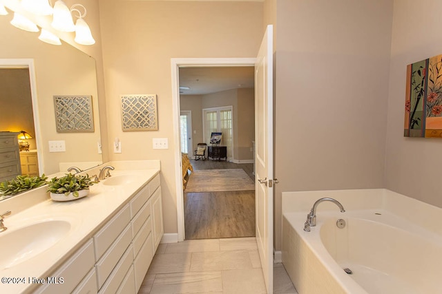 bathroom with vanity, hardwood / wood-style floors, and tiled tub