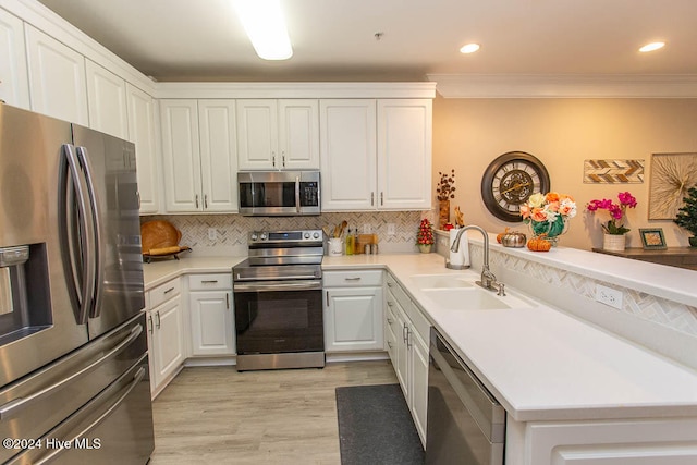 kitchen with sink, appliances with stainless steel finishes, light hardwood / wood-style flooring, crown molding, and white cabinets