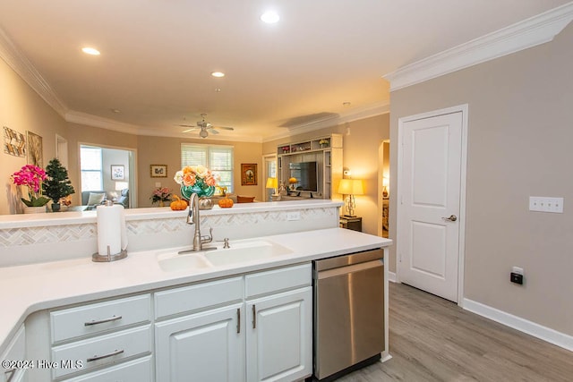 kitchen featuring sink, ornamental molding, stainless steel dishwasher, light hardwood / wood-style flooring, and white cabinets