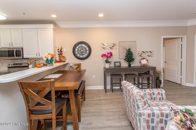 dining room featuring ornamental molding and light hardwood / wood-style floors