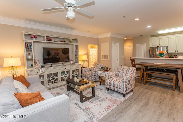 living room featuring ornamental molding, light hardwood / wood-style floors, and ceiling fan