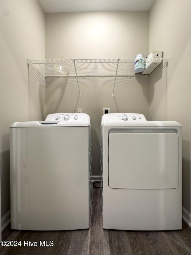 laundry area with washer and dryer and dark wood-type flooring