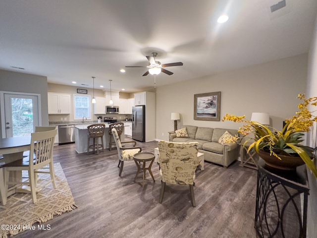 living room with dark hardwood / wood-style floors and ceiling fan