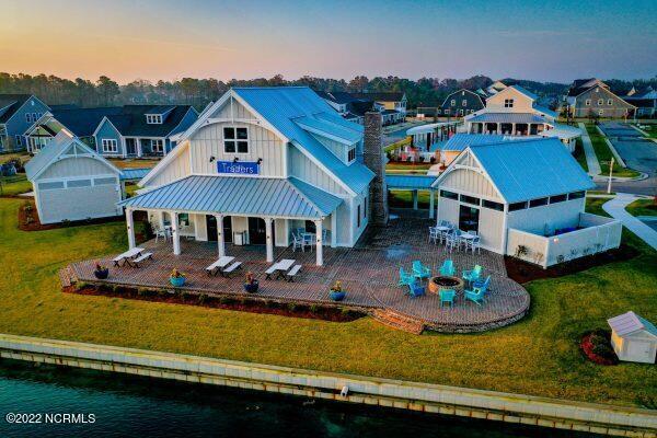 exterior space with a water view, a fire pit, a patio area, and a lawn