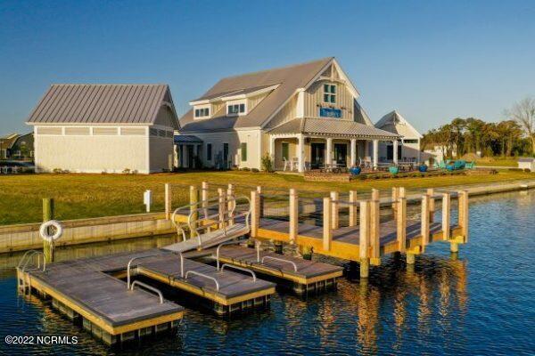 view of dock with a lawn and a water view