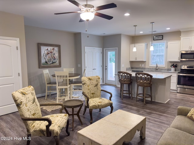 living room with ceiling fan, dark hardwood / wood-style flooring, and sink