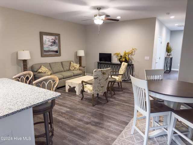 living room featuring ceiling fan and dark hardwood / wood-style flooring