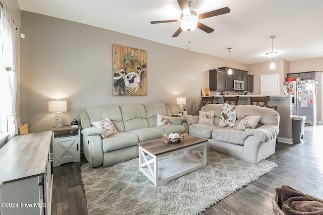 living room with dark wood-type flooring and ceiling fan