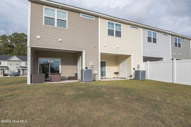 rear view of house with a patio, central AC, and a yard