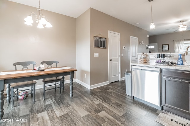 kitchen with light stone counters, sink, stainless steel dishwasher, dark hardwood / wood-style floors, and pendant lighting