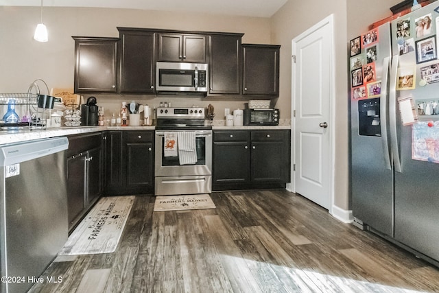 kitchen with stainless steel appliances, dark wood-type flooring, and decorative light fixtures