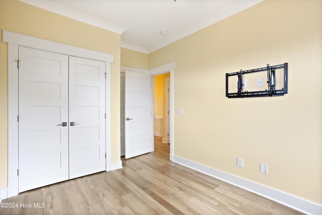 304 Birmingham Ave Unit 2, Carolina Beach, NC 28428 - unfurnished bedroom with light wood-style floors, crown molding, baseboards, and a closet