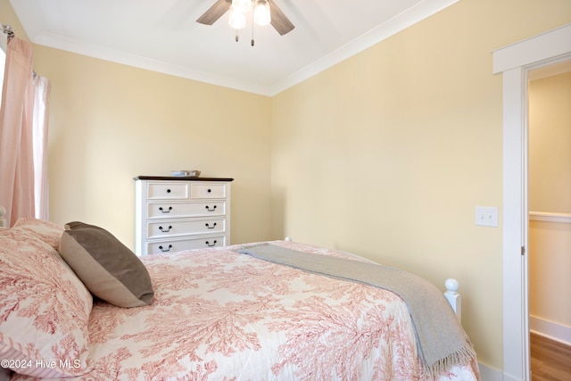 bedroom featuring ceiling fan, wood-type flooring, and ornamental molding